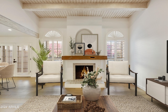 living area featuring beamed ceiling, hardwood / wood-style floors, a fireplace, and wood ceiling