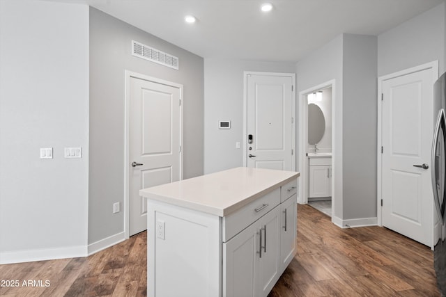 2511 W Queen Creek Rd Unit 116, Chandler, AZ 85248 - kitchen featuring wood finished floors, baseboards, recessed lighting, and light countertops