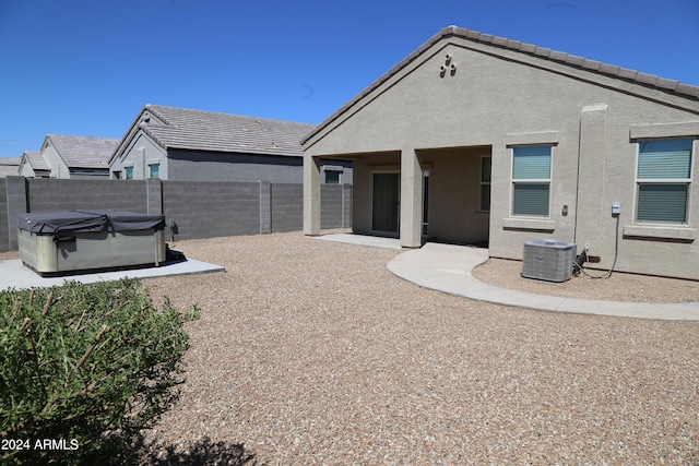 back of house featuring a hot tub, a patio, and central AC unit