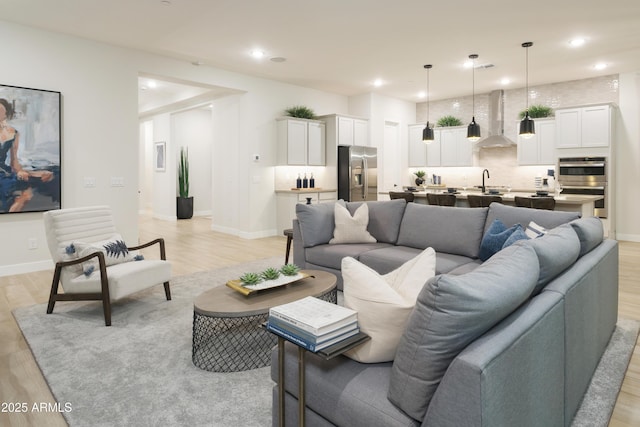 living room featuring sink and light hardwood / wood-style flooring