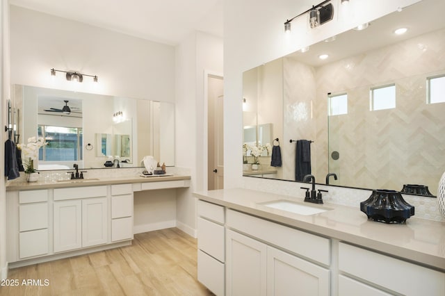 bathroom with a shower, ceiling fan, vanity, and hardwood / wood-style flooring