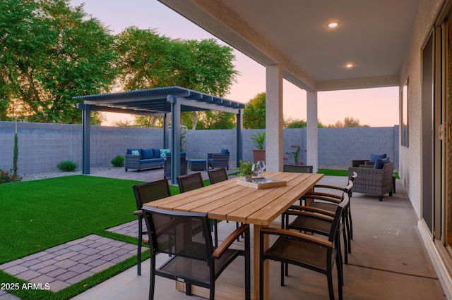 patio terrace at dusk featuring a lawn, a pergola, and an outdoor living space