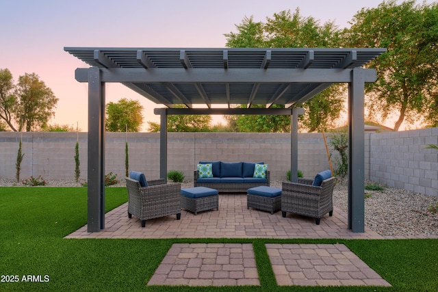 patio terrace at dusk featuring a yard, a pergola, and an outdoor hangout area