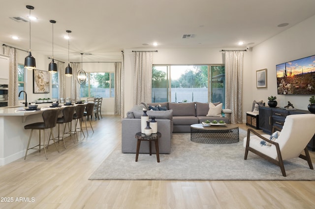 living room featuring light wood-type flooring and a chandelier