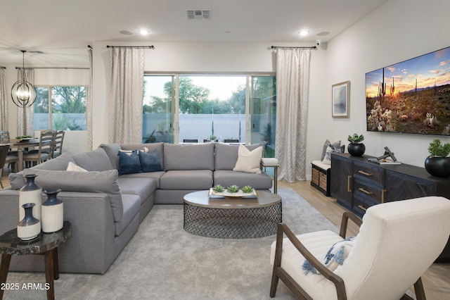 living room with a chandelier and light wood-type flooring