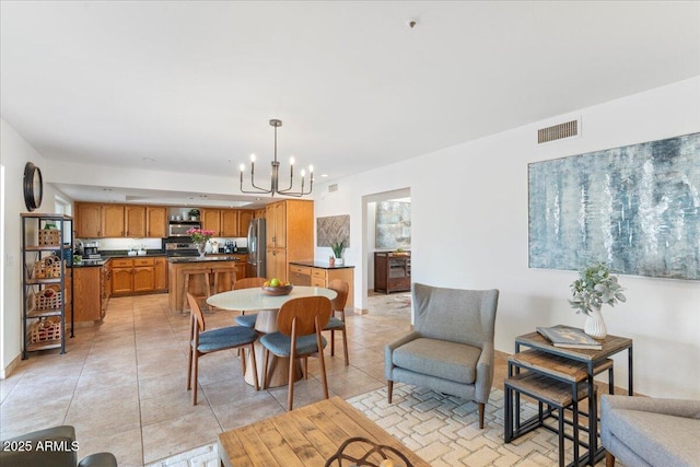 dining space featuring visible vents, a notable chandelier, and light tile patterned flooring