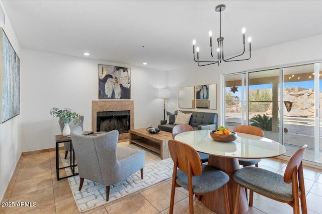 dining room featuring a chandelier, light tile patterned flooring, a tile fireplace, recessed lighting, and baseboards