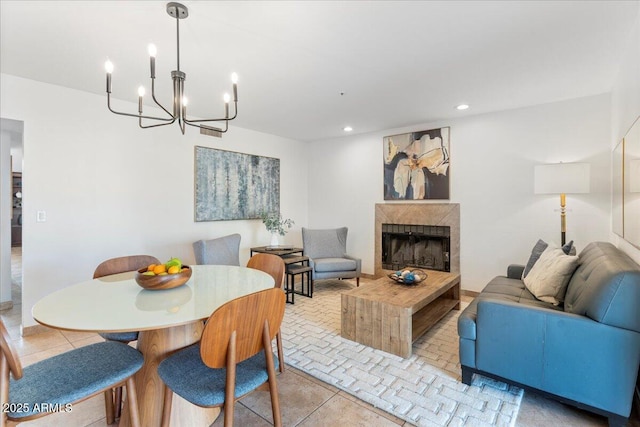 dining room with light tile patterned floors, a fireplace, a chandelier, and recessed lighting