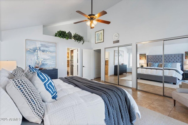 bedroom featuring multiple closets, ceiling fan, high vaulted ceiling, and light tile patterned floors