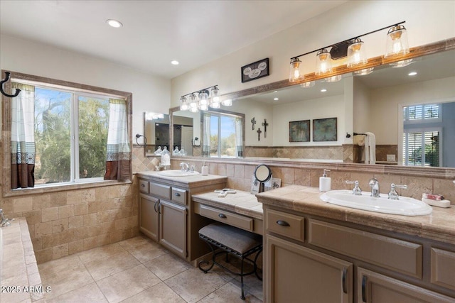 full bathroom featuring plenty of natural light, vanity, tile walls, and recessed lighting