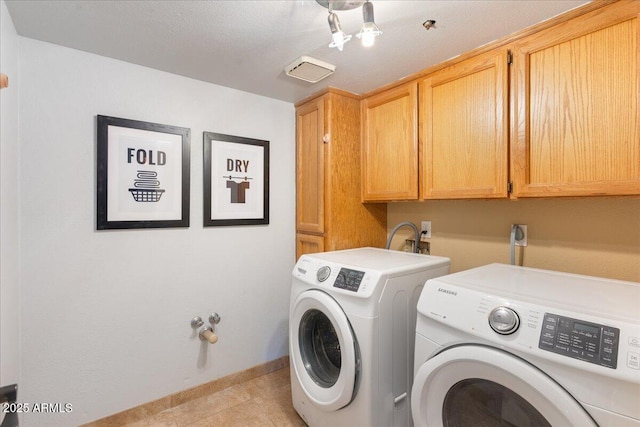 washroom with cabinet space, light tile patterned floors, baseboards, and washer and dryer