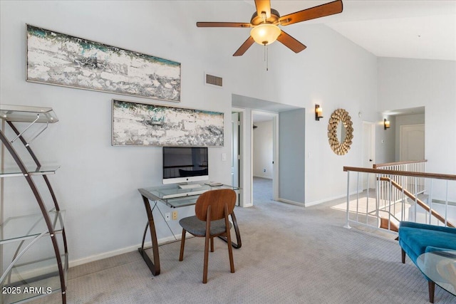 office with baseboards, visible vents, a ceiling fan, light colored carpet, and high vaulted ceiling