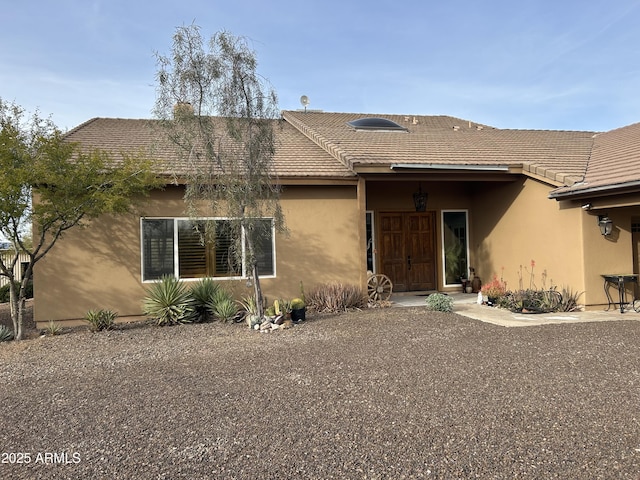 view of front facade with a tile roof and stucco siding