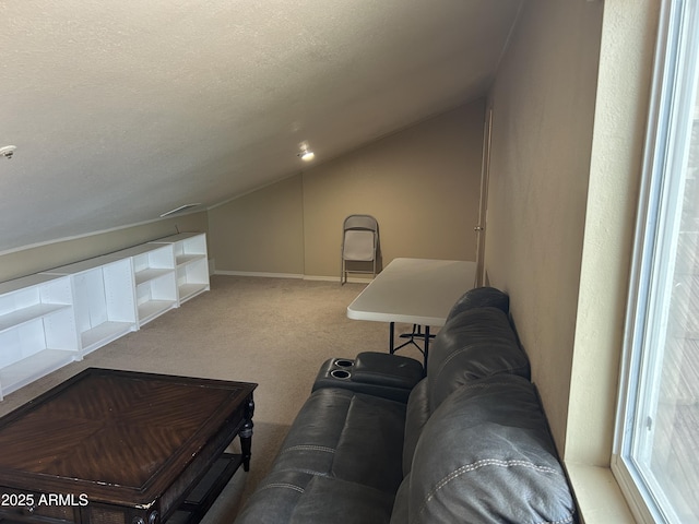 interior space with a textured ceiling, carpet flooring, and lofted ceiling