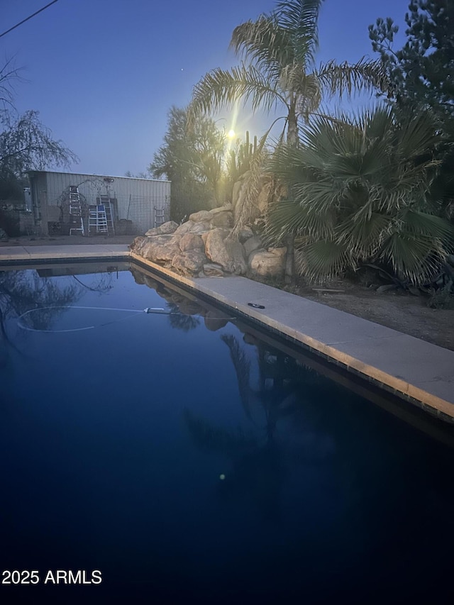 pool at dusk with an outdoor pool