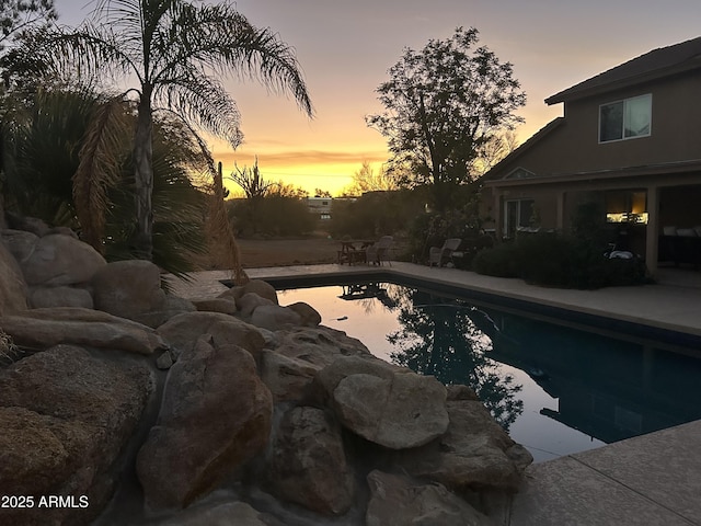 pool at dusk with an outdoor pool