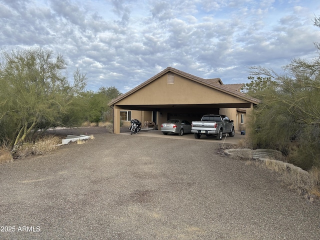 view of parking / parking lot with driveway and a carport