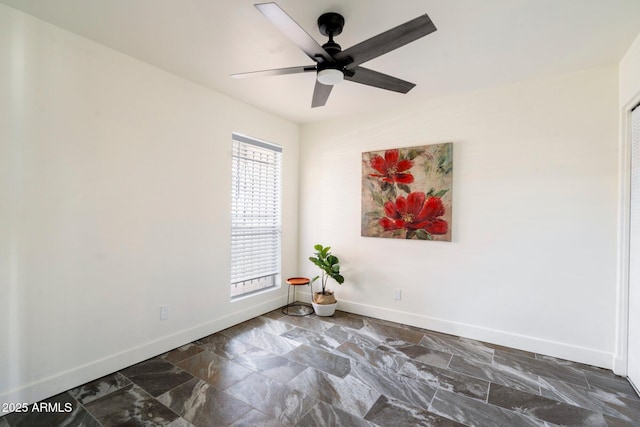 spare room with ceiling fan and plenty of natural light