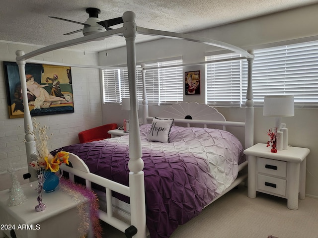 bedroom with ceiling fan, a textured ceiling, and light carpet