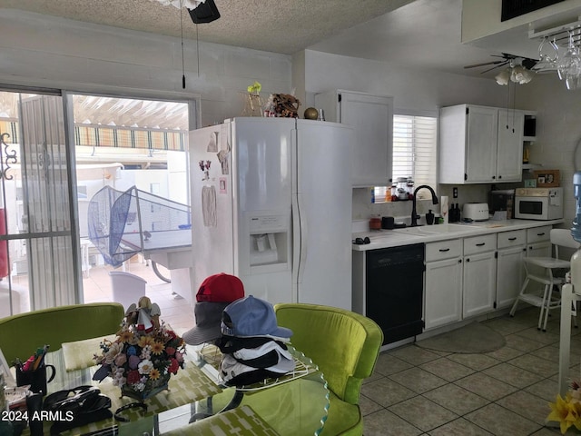 kitchen featuring a textured ceiling, white appliances, sink, light tile patterned floors, and white cabinets