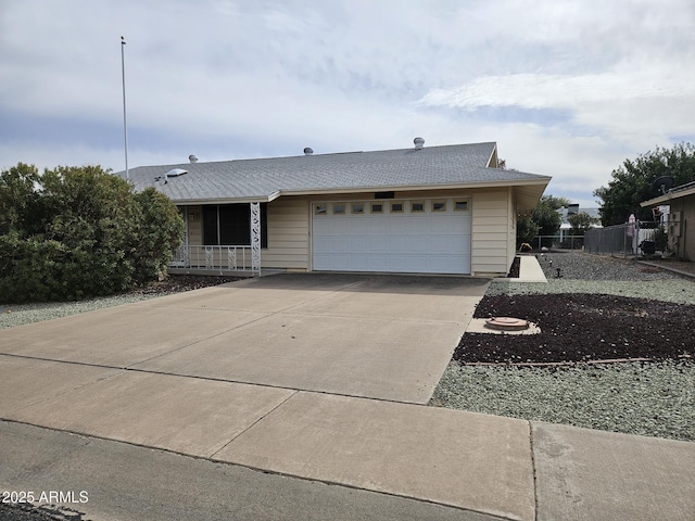 ranch-style home with a garage, driveway, and fence