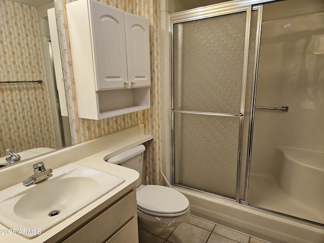 full bath featuring tile patterned flooring, toilet, vanity, an enclosed shower, and wallpapered walls