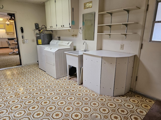 laundry room featuring cabinet space, washer and clothes dryer, baseboards, and water heater