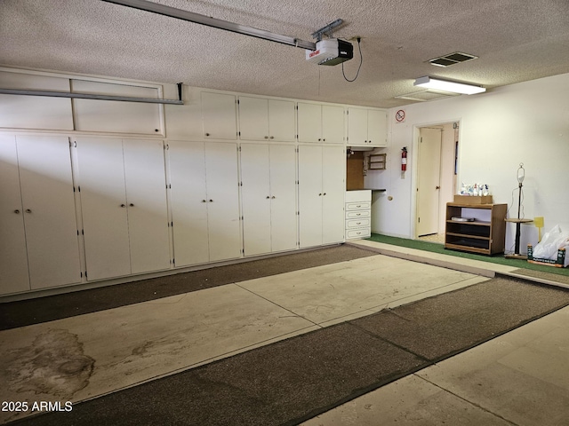 garage featuring visible vents and a garage door opener