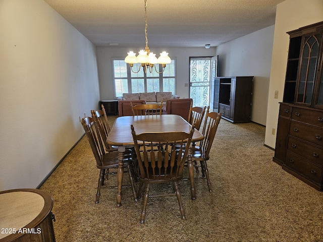 dining room with an inviting chandelier, baseboards, and carpet flooring