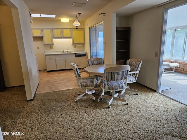 dining area with baseboards and light colored carpet