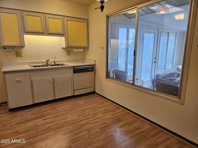 kitchen with a wealth of natural light, light countertops, dishwasher, and a sink