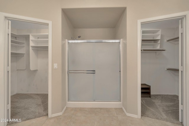 bathroom featuring tile patterned floors and a shower with door