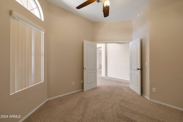 unfurnished room with ceiling fan and light colored carpet