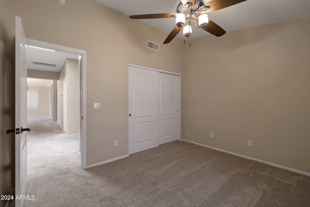 unfurnished bedroom with ceiling fan, a closet, and light carpet