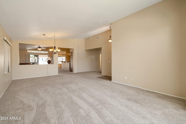 unfurnished living room featuring carpet, vaulted ceiling, and ceiling fan with notable chandelier