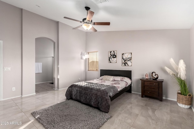 bedroom with arched walkways, ceiling fan, vaulted ceiling, and baseboards