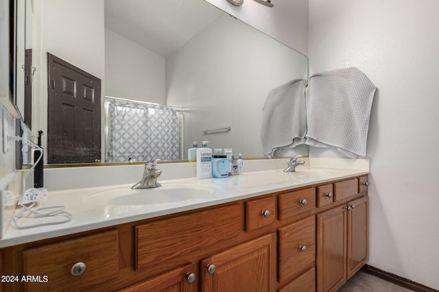 bathroom with lofted ceiling and dual vanity