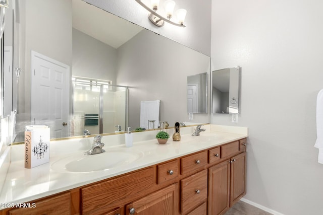 full bath featuring a sink, a shower stall, baseboards, and double vanity