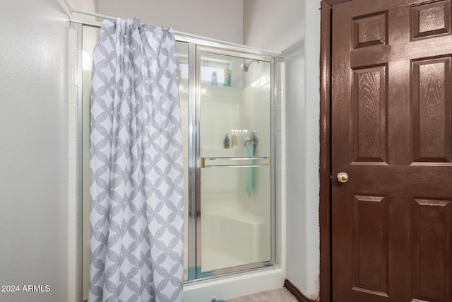 bathroom with a shower with door