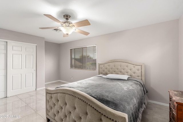 bedroom with light tile patterned floors, visible vents, baseboards, a ceiling fan, and a closet