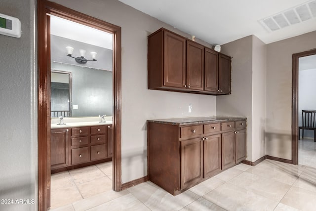 interior space featuring sink, a notable chandelier, and light tile patterned floors