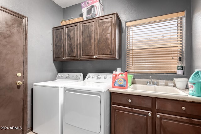 washroom with sink, washing machine and clothes dryer, and cabinets