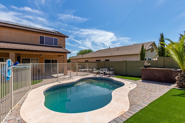 view of swimming pool with ceiling fan and a patio area