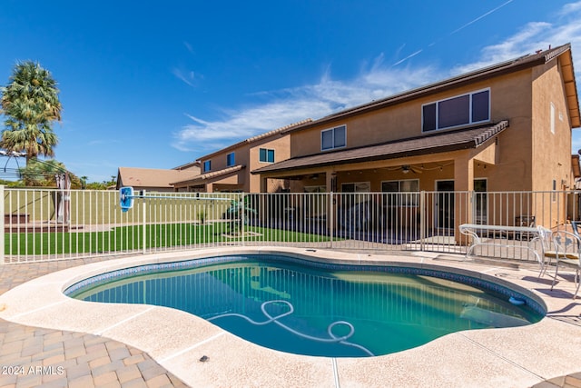 view of pool featuring ceiling fan, a patio area, and a yard