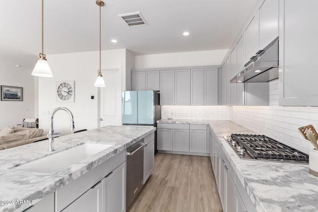 35612 N Lodestone Dr, San Tan Valley, AZ 85144 - kitchen featuring a sink, stainless steel appliances, light wood-style flooring, light stone countertops, and backsplash