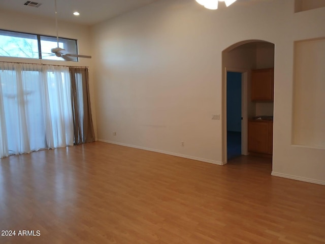 spare room with light wood-type flooring and ceiling fan