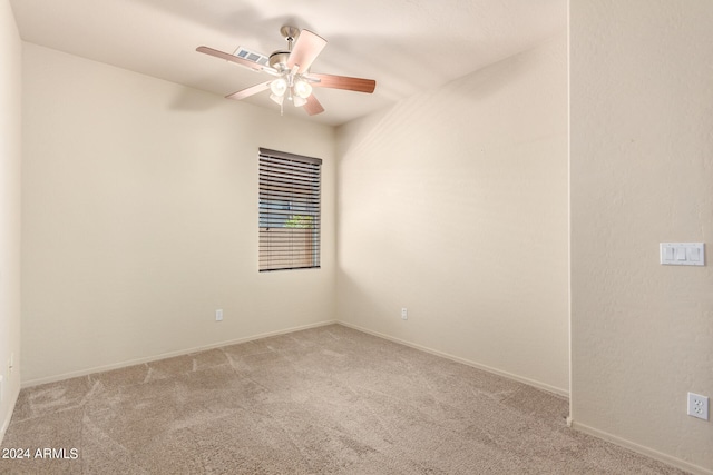 spare room featuring light carpet and ceiling fan