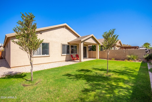 rear view of house featuring a patio and a lawn