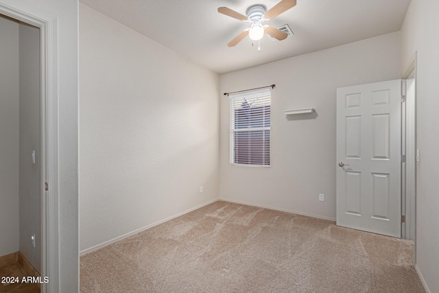 empty room featuring light colored carpet and ceiling fan