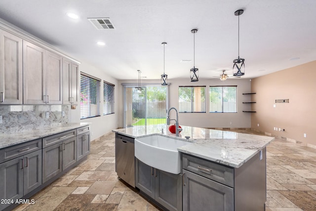 kitchen featuring a wealth of natural light, dishwasher, an island with sink, and decorative light fixtures